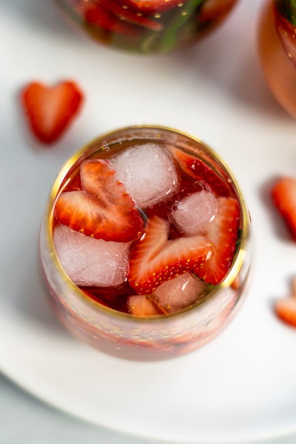 overhead view of a sangria glass wit ice cubes and strawberry shaped hearts