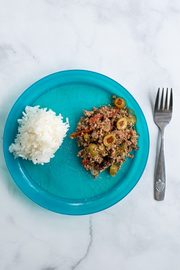 blue kids plate with a small portion serving of cuban picadillo with rice just like an adult would eat it