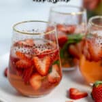 three glasses of strawberry sangria on a plate made with rose wine