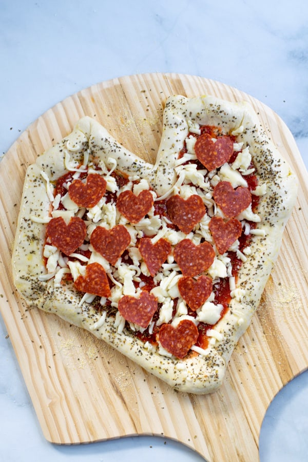 unbaked pizza on a paddle ready to be transferred to the oven