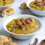 a pinterest pin showing a bowl with split pea soup topped with ham and sprinkled with fresh thyme