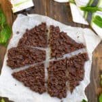 Chocolate Mint Crunch Bark in pieces on parchment paper