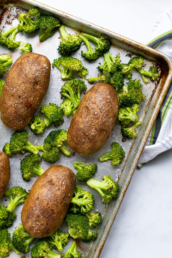 baked potatoes and roasted broccoli on a sheet pan