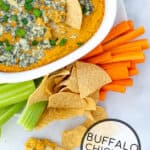 Buffalo Chickpea Dip with tortilla chips and veggie sticks for dipping
