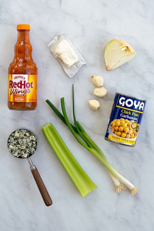 all of the ingredients layer out for making buffalo chickpea dip