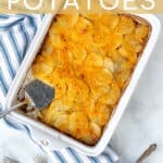 homemade au gratin potatoes in a white casserole dish with a some on a plate next to it with a Pinterest Title 'Au Gratin Potatoes'