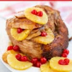 spiral ham on a platter with pineapples and cherries with a brown sugar glaze