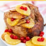 ham on a platter with pineapples and cherries with a brown sugar glaze