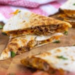 Pinterest Pin with post title showing photo of two cut quesadillas on a cutting board stacked to show insides