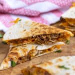 Pinterest Pin with post title showing photo two cut quesadillas stacked showing the ingredients inside