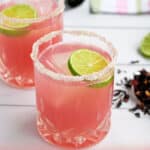Pinterest Pin with title of recipe Hibiscus Margaritas and a picture of a bright pink margarita with a lime
