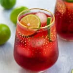 pinterest pin for Hibiscus Iced Tea Sparkler showing bright red tea with lime slices and ice