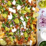 Pinterest Pin with a sheet pan of carnitas nachos with cheese and toppings