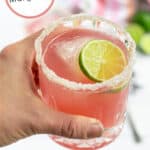Pinterest Pin with title of recipe Hibiscus Margaritas and a picture of a hand holding a pink margarita