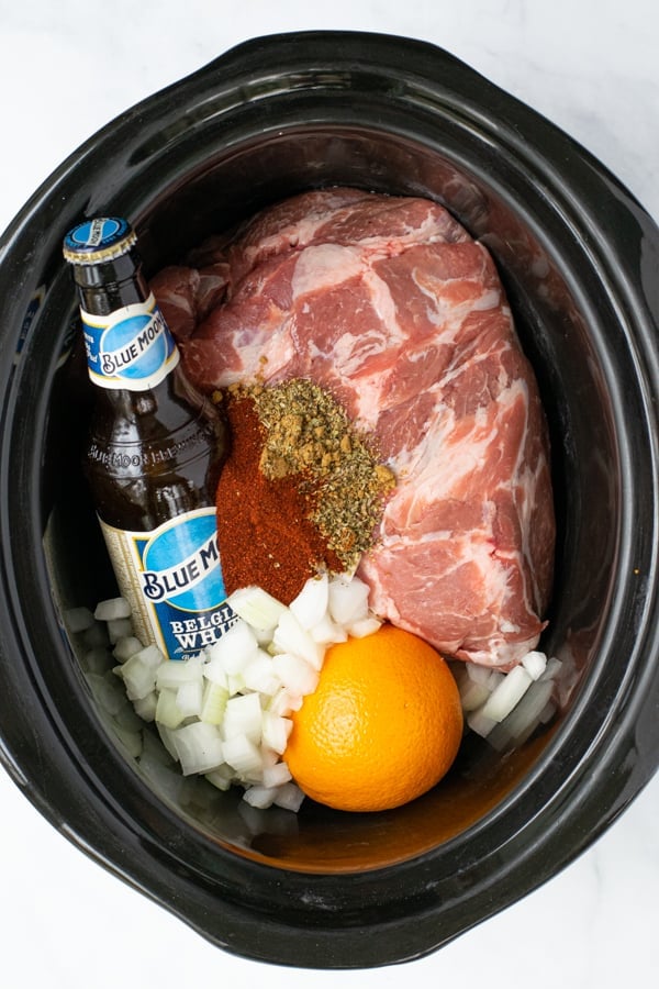 all of the ingredients needed to make crockpot carnitas together in the crockpot