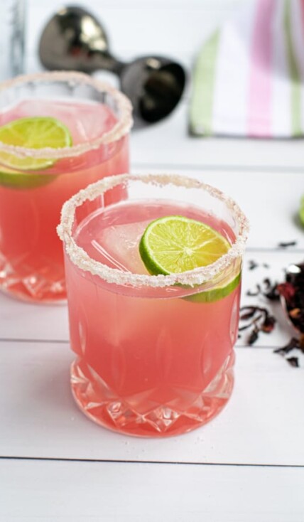 a glass of the best hibiscus margarita recipe with a salted-rim and a slice of lime