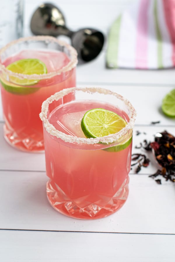 a glass of the best hibiscus margarita recipe with a salted-rim and a slice of lime