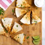 Pinterest Pin with post title showing photo two cut quesadillas on a cutting board