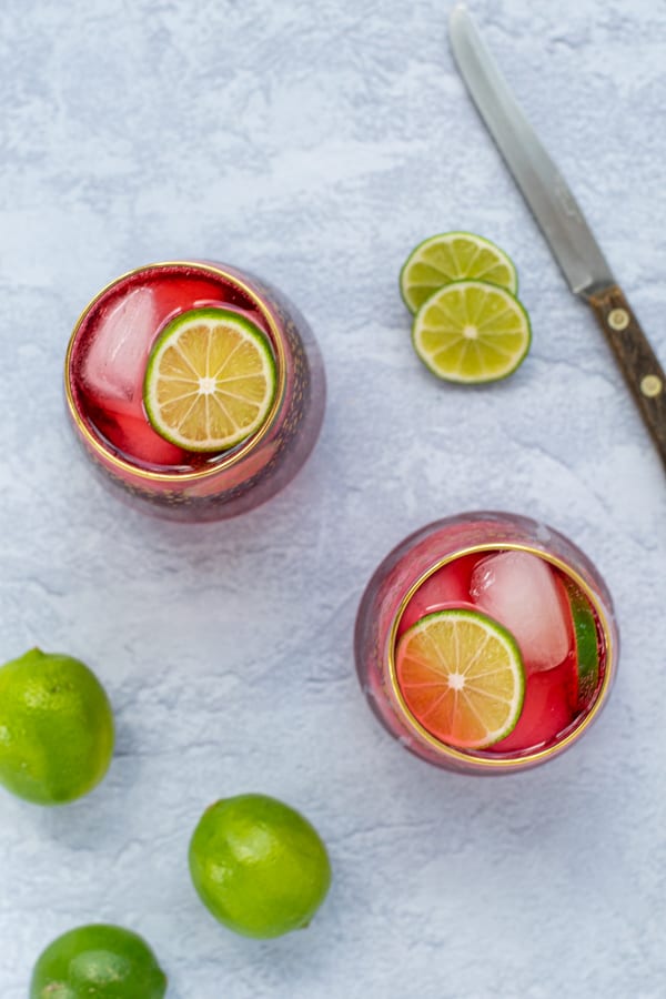 overhead view of two glasses full of Hibiscus Iced Tea Sparkler with lime slices
