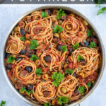 Pinterest Pin for Pasta Puttanesca showing a large silver pan full of pasta garnished with olives and parsley