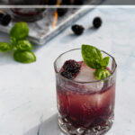 Pinterest Pin for Bourbon Blackberry Smash Cocktail showing photo of purple drink garnished with basil leaves and fresh blackberries