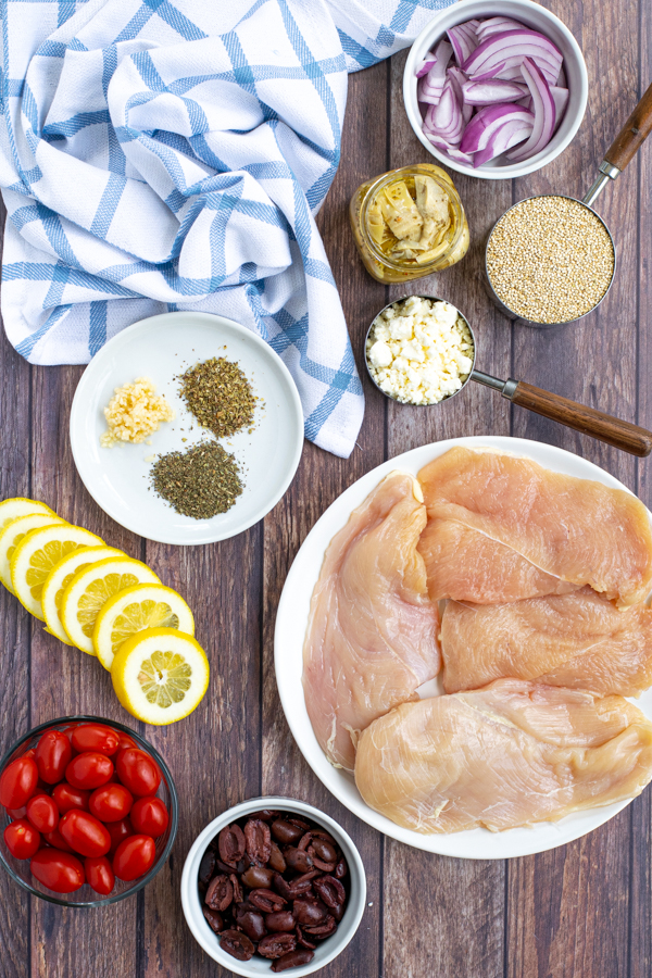 all of the ingredients you need laid out on a table to make greek chicken bake