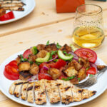 Pinterest Pin for Grilled Chicken Panzanella Salad showing a white plate with a grilled chicken breast and a pile of panzanella salad