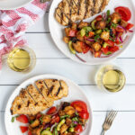 Pinterest Pin for Grilled Chicken Panzanella Salad showing a white plate with a grilled chicken breast and a pile of panzanella salad