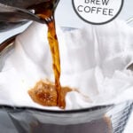 Pinterest Pin for how to make cold brew coffee showing coffee concentrate being poured into cheese cloth