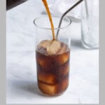 Pinterest Pin showing cold brew concentrate being poured into a glass filled with ice and a metal straw