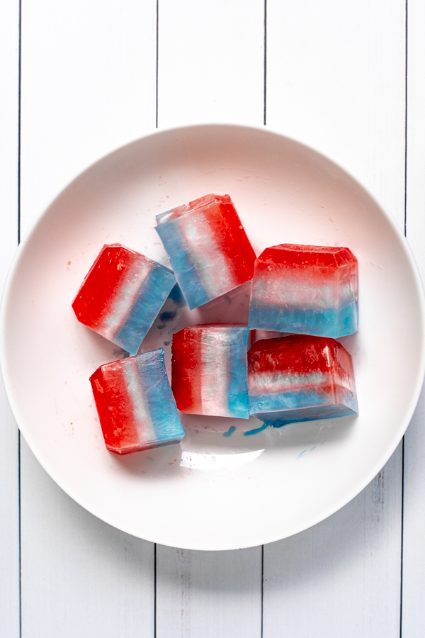a large white bowl filled with layered red, white, and blue ice cubes