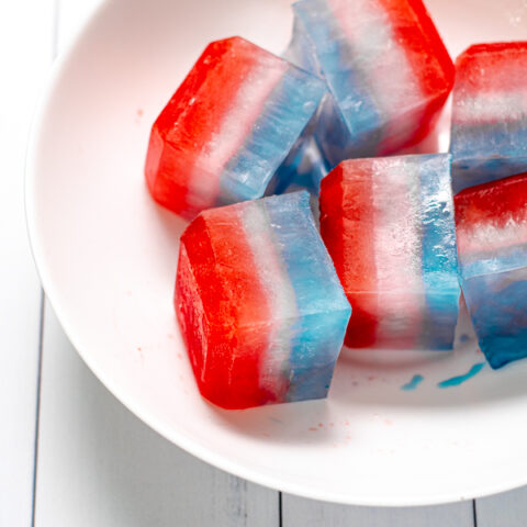 close up of layered red, white, and blue ice cubes in a large white bowl