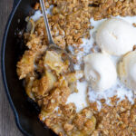 Grilled Apple Crisp Pinterest Pin showing the cooked dessert topped with ice cream and a spoon scooping some out