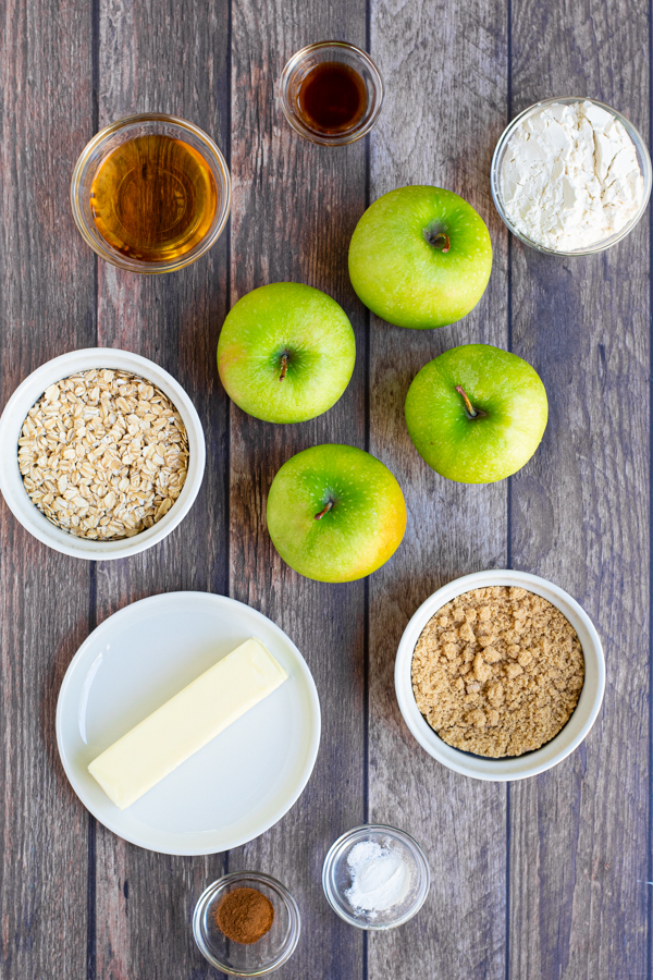 all of the ingredients need to make grilled apple crisp laid out on a table, like apples, flour, sugar, and oats