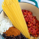 Pinterest Pin for One-Pot Taco Spaghetti with image of uncooked ingredients laid out in a pot