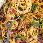 Pinterest Pin for One-Pot Taco Spaghetti with image of close up of cooked spaghetti with black beans, tomatoes, and cheese