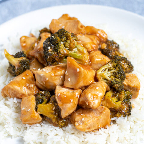 close up view of baked General Tso's Chicken on a bed of rice on a white plate