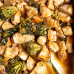 Pinterest Pin for Baked General Tso's Chicken showing the saucy chicle and broccoli up close in the baking dish