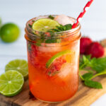 Pinterest Pin for Strawberry Mojito Mocktail showing a pink beverage on a cutting board garnished with fresh mint and lime