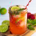 Pinterest Pin for Strawberry Mojito Mocktail showing a photo of a glass of pink beverage garnished with limes and fresh mint