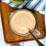 Pinterest Pin with text overlay Greek Yogurt Southwest Sauce showing photo of spoon in a glass measuring cup.