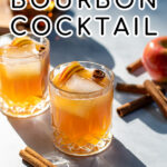 Pinterest Pin with text overlay Apple Cider Bourbon Cocktail, image of whiskey glass full of bourbon cider garnished with cinnamon sticks and apples.