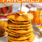 Pinterest Pin with Text overlay Pumpkin Pancakes showing a stack of pancakes on a white plate with a pad of butter and maple syrup being poured on the top and dripping down the sides of the stack.