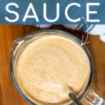 Pinterest Pin with text overlay Greek Yogurt Southwest Sauce showing photo of a glass measuring cup filled with with sauce with a spoon in the sauce.