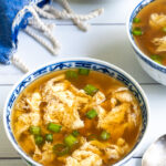 Pinterest Pin with text over lay 'Egg Drop Soup, Easy to make in 10 minutes' with image of small bowl full of soup and topped with green onions.
