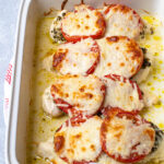 Pinterest Pin with text overlay 'Easy Pesto Chicken Bake' showing baking dish with baked chicken, pesto, tomatoes, and melted mozzarella cheese.