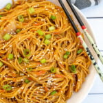 Pinterest Pin with text, One-Pot Teriyaki Noodles. Image of white bowl full of saucy noodles sitting next to a pair of chopsticks.