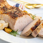 Pinterest Pin with Text, Pork Loin Roast with Apples, Onions, & Potatoes. Image showing sliced pork on serving platter.