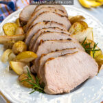 Pinterest Pin with Text, Roasted Pork Loin with Apples, Onions, and Potatoes. Image showing sliced pork on serving platter.