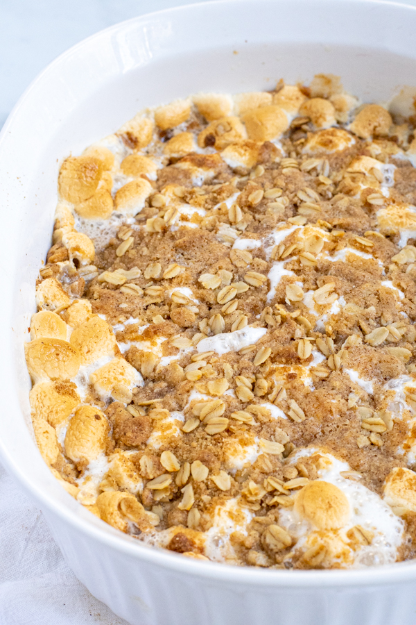 Sweet Potato Casserole with Marshmallows and Oat Streusel in a white casserole dish with brown marshmallows.